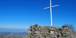 Wooden cross at the summit of Mount Papoutsa in the Troodos Mountains, Cyprus, standing against winter skies and strong winds